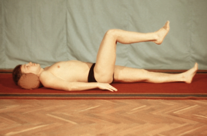 Рис. 12а). Примерный комплекс упражнений при компрессионном переломе тел грудных или поясничных позвонков в положении лежа на спине и животе (второй период): удержание полусогнутой ноги на весу