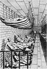 A drawing of a large room, with three long tiers of beds next to the left wall, with men lying in them. The top tier consists of hammocks attached by ropes to ceiling bolts. The middle tier appears to be one large flat wooden platform. The lower tier consists of men lying on the bare floor.