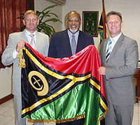 Edward Natapei CENTER presenting a ceremonial flag to foreign diplomats.jpg
