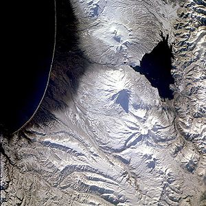 Кроноцкий вулкан (в центре кадра с треугольной тенью) и вулкан Крашенинникова, спутниковый снимок. Ноябрь 1985. Север снизу справа.
