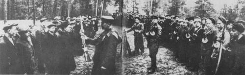 Вручение боевого оружия партизанам, прибывшим в отряд. 1942.