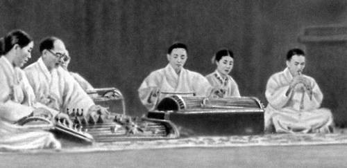 Оркестр народных инструментов аккомпанирует исполнителю на каягыме заслуженному артисту КНДР Ан Ги Ок (второй слева).
