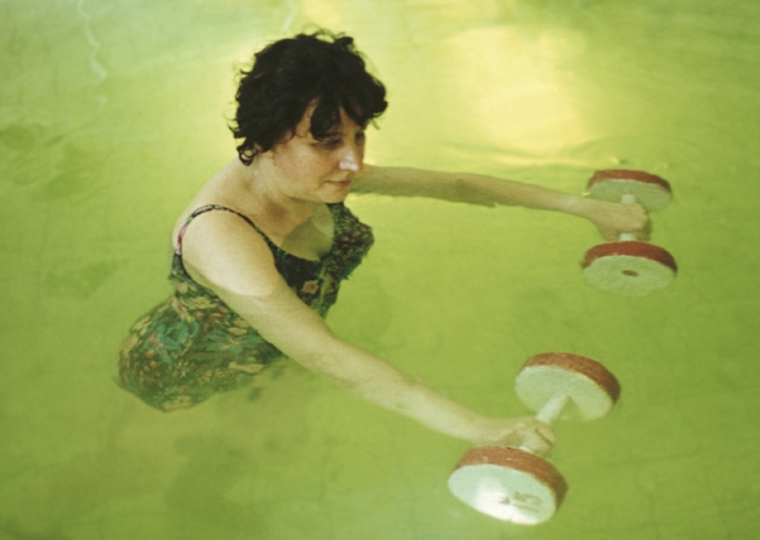 Рис. 6д). Физические упражнения в воде при посттравматической контрактуре в правом плечевом суставе: с водными гантелями
