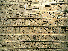 Плоская камень бежевого цвета с иероглифиеской надписью, написанной в горизонтальных рядах
