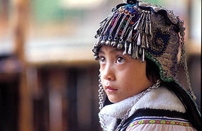 Девочка хани в традиционном детском головном уборе.