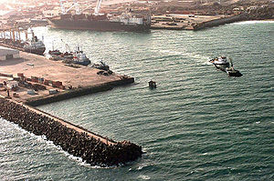 в какой стране находится город могадишо. 300px Aerial view of the port of Mogadishu. в какой стране находится город могадишо фото. в какой стране находится город могадишо-300px Aerial view of the port of Mogadishu. картинка в какой стране находится город могадишо. картинка 300px Aerial view of the port of Mogadishu. Могадишо является не только официальной столицей Сомали, но и крупнейшим городом страны, ее культурным, индустриальным и финансовым центром. Город был основан арабскими колонистами примерно в IX веке, а название его означает «место шаха». История Могадишо довольно насыщена и интересна: долгое время он принадлежал мусульманским султанатам, после оказался под контролем Португалии, а затем был захвачен султаном Занзибара. В начале прошлого века город был выкуплен Италией, однако спустя полвека перешел в состав Сомали и получил статус столицы. К сожалению, с начала 1990-х годов Могадишо превратился в центр непрекращающейся гражданской войны, поэтому поездка сюда сопряжена с довольно большим риском. Однако, несмотря на весьма сложную военно-политическую ситуацию, в городе сохранилось множество красивых старинных улочек и зданий в афро-арабском стиле. Также в городе действует несколько интереснейших музеев, Национальный университет и международный аэропорт.