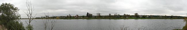 Панорамная фотография деревни Герпеля с противоположного берега реки Олонки